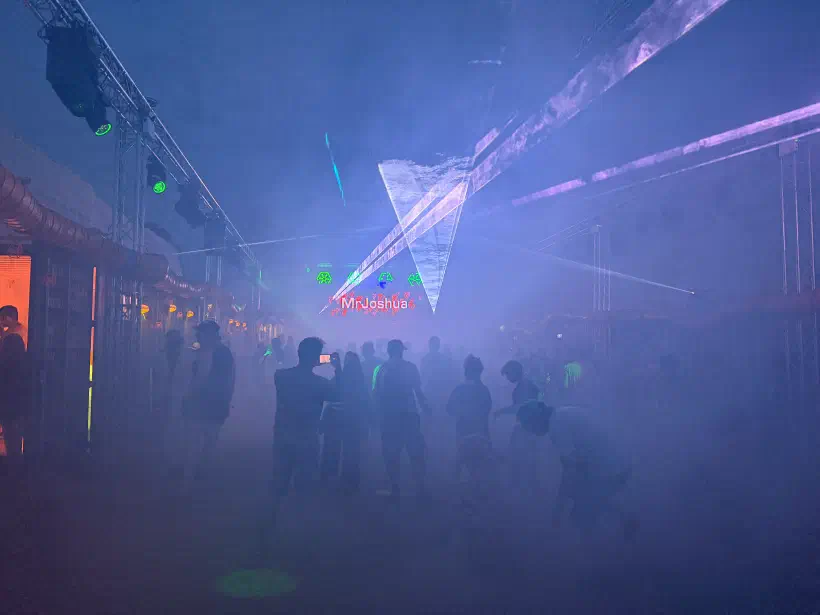 a dance floor at night lasers, projections, beams of light and smoke machines provide atmospheric effects