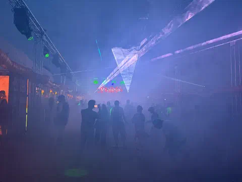 a dance floor at night lasers, projections, beams of light and smoke machines provide atmospheric effects